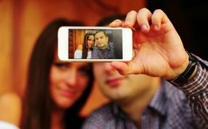 Couple taking self-portrait photos with mobile smart phone